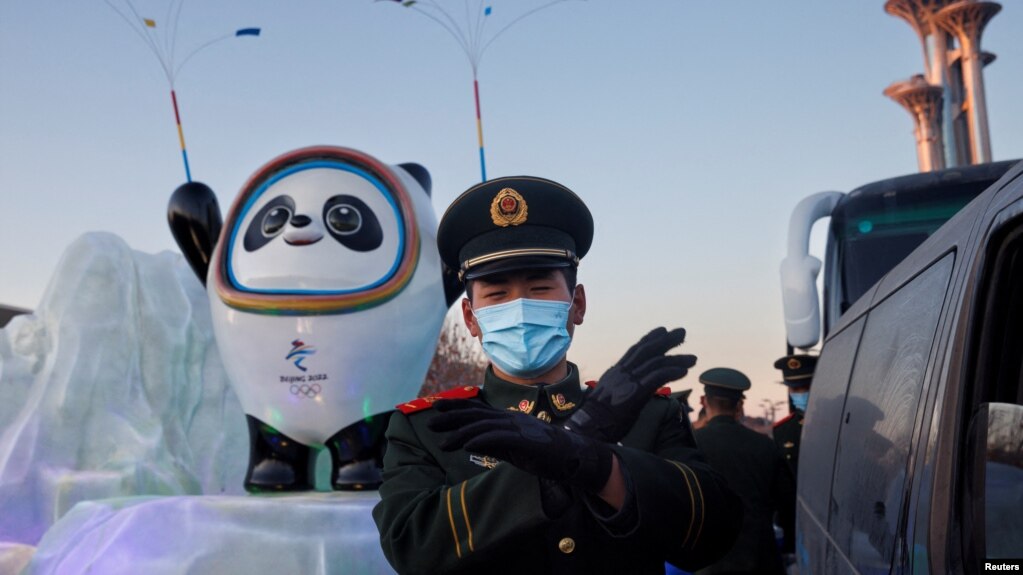 一名中國武警在北京的冬奧會吉祥物前給拍照者做手勢。 (2022年1月15日)