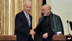 Afghan President Hamid Karzai, right, shakes hands with US Vice President Joe Biden during a press conference in Kabul, 11 Jan 2011
