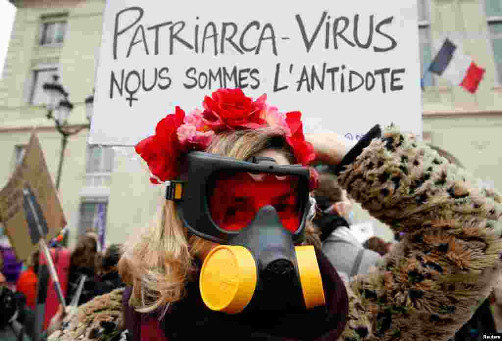 Una mujer con una máscara de gas asiste a una protesta exigiendo igualdad en el Día Internacional de la Mujer en París, Francia, el 8 de marzo de 2020. La pancarta dice: "Virus del patriarcado. Somos el antídoto".
