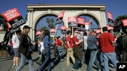 FILE - striking writers walk the picket line outside Paramount Studios in Los Angeles.