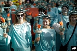 Protesters dressed as the Statue of Liberty march during a demonstration in the center of Brussels, May 24, 2017.