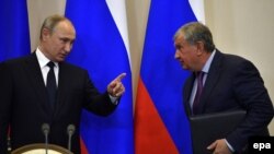 Russia -- Russian President Vladimir Putin (L) talks with Rosneft chief executive Igor Sechin during a signing ceremony following his meeting with Italian Prime Minister at the Bocharov Ruchei state residence in Sochi, May 17, 2017
