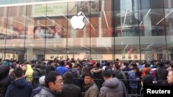 FILE - Customers wait for the opening of an Apple store in Shenyang, Liaoning province, Feb. 28, 2015.
