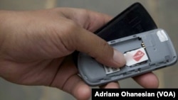 A mobile phone user in South Sudan checks his SIM card. 