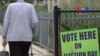 An elder walks pass the voting sign placed on the fence at one of the public schools in Lowell, Massachusetts, Thursday, September 8, 2016.