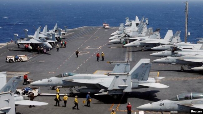 Foto de Archivo - El personal de la Armada estadounidense se prepara para lanzar un avión de combate F18 en la cubierta del USS Carl Vinson durante un ejercicio de rutina en el Mar de China Meridional, 3 de marzo de 2017.