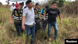 Police officers carry the body of Sebastian Woodroffe, a 41-year-old Canadian citizen, who was beaten and strangledin the jungle region of Ucayali after members of an indigenous community accused him of killing a revered medicine woman.