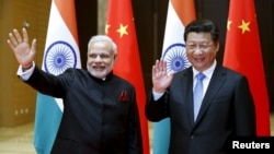 14일 중국 산시성에 도착해 시진핑 중국 국가 주석(오른쪽)의 영접을 받은 나렌드라 모디 인도 총리가 기자단을 향해 손을 흔들고 있다. 