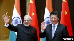 Indian Prime Minister Narendra Modi (L) and Chinese President Xi Jinping wave to journalists before they hold a meeting in Xian, Shaanxi province, China, May 14, 2015. 