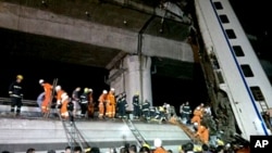 Chinese firefighters work to rescue survivors after a Chinese high-speed train derailed and two of its carriages fell off a bridge after a lightning strike knocked out power on the line in China's Zhejiang province, July 23, 2011