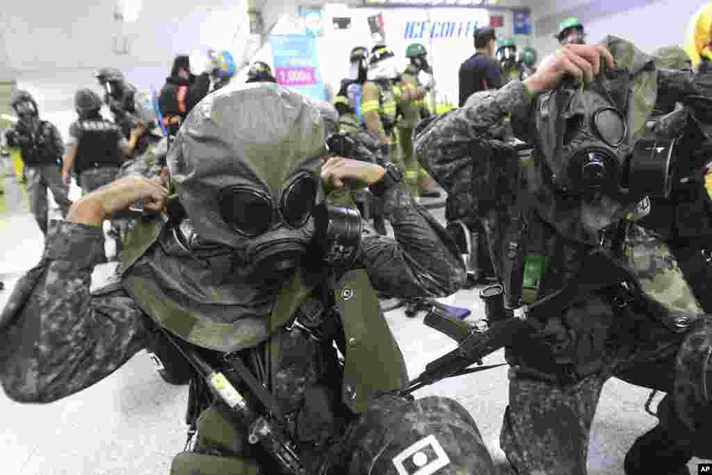 South Korean army soldiers put on gas masks during South Korea-U.S. joint military exercises at a subway station in Seoul, August 19, 2013.