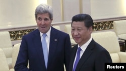 U.S. Secretary of State John Kerry (L) shakes hands with Chinese President Xi Jinping at the Great Hall of the People in Beijing, China, May 17, 2015. 