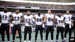 Baltimore Ravens players link arms during the playing of the U.S. national anthem before an NFL football game against the Jacksonville Jaguars at Wembley Stadium in London, Britain, Sept. 24, 2017.