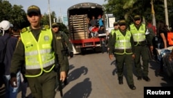 Migrantes venezolanos son transportados en un camión escoltado por la policía durante una operación por parte de la policía colombiana para expulsar a los migrantes que estaban en un centro deportivo en Cúcuta, Colombia, el miércoles, 24 de enero de 2018.