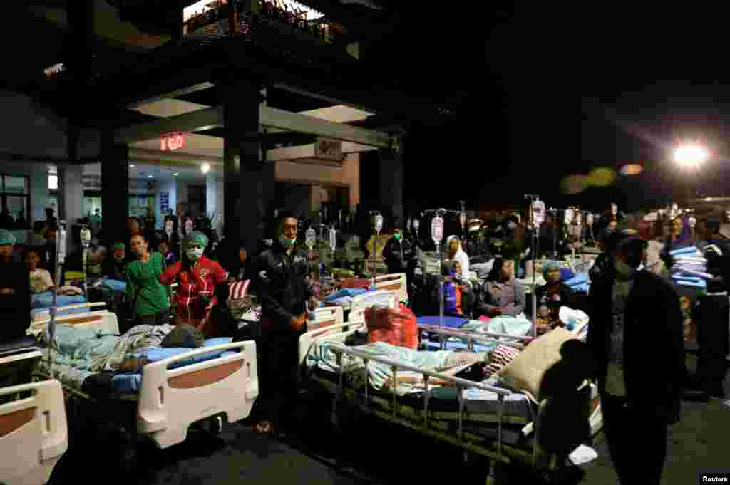 Patients are seen outside a government hospital near Denpasar, Bali, Indonesia, following a strong earthquake nearby Lombok island.