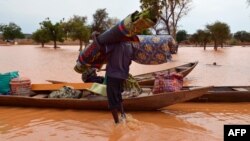 Un homme transporte ses effets personnels sur une pirogue lors d'une inondation dans un district de Niamey, au Niger, le 5 septembre 2013.