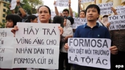 Vietnamese protesters hold banners reading 'Get out Formosa' and 'Formosa destroys the environment, which is a crime' during a rally denouncing recent mass fish deaths in Vietnam's central province, in Hanoi, Vietnam, May 1, 2016.