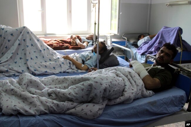 Injured men receive treatment at a hospital after a clash between Taliban and security forces in Kunduz province, Afghanistan, April 13, 2019.