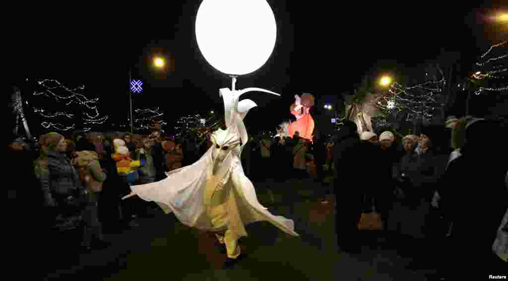An artist performs during "The Parade of Light" show by German company "Helmnot", in Riga, Jan. 18, 2014.
