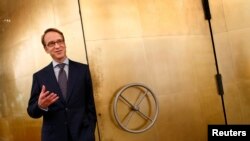 FILE - Germany's Bundesbank President Jens Weidmann stands beside the door of a giant safe at the money museum next to the Bundesbank headquarters, in Frankfurt, Germany, May 17, 2013.
