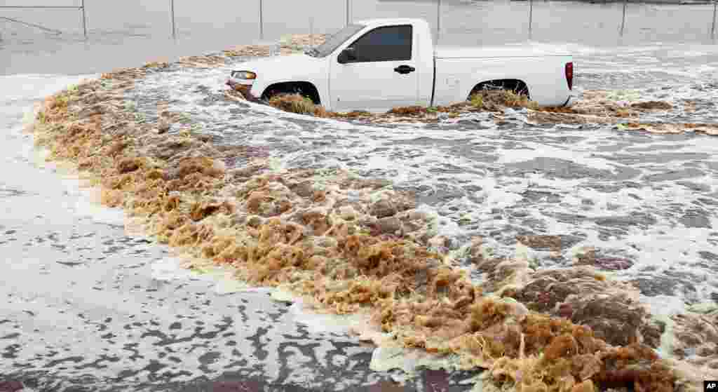 A truck creates a wake as its driver tries to navigate a severely flooded street amid heavy rains in Phoenix, Arizona, USA. Storms that flooded several Phoenix-area freeways and numerous local streets during the morning commute set an all-time record for rainfall in Phoenix in a single day.