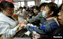 چین میں روایتی دواؤں کی ایک فارمیسی پر خریداروں کا ہجوم