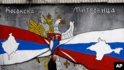 Grafit u Kosovskoj Mitrovici sa srpskom i ruskom zastavom i mapama Krima i Kosova,Foto: AP Photo/Darko Vojinovic