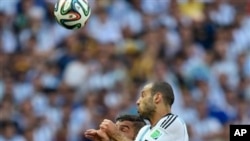 Argentina's Javier Mascherano leaps to head the ball past Iran's Ashkan Dejagah during the group F World Cup soccer match between Argentina and Iran at the Mineirao Stadium in Belo Horizonte, Brazil, Saturday, June 21, 2014. 
