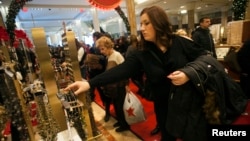 FILE - Shoppers browse at a Macy's store in New York.
