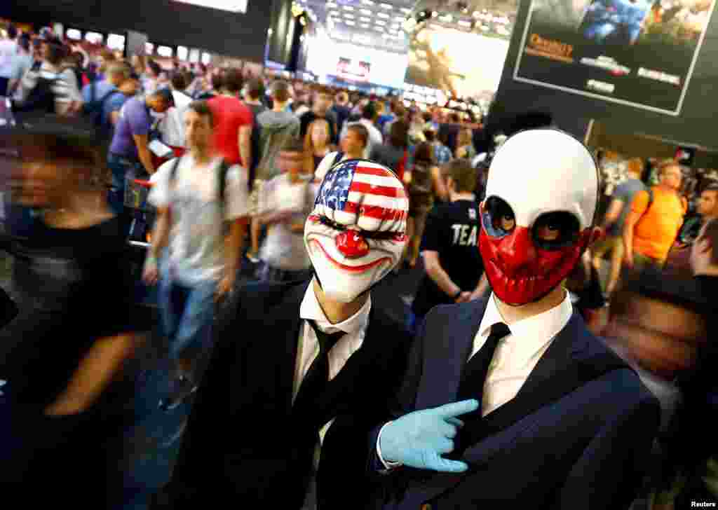 Orang-orang yang mengenakan kostum atau biasa disebut cosplayer berpose di sela-sela pameran Gamescom di Cologne, Jerman.