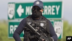 Mexico police guard an area where dozens of bodies were found