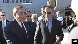 U.S. Secretary of Defense Leon Panetta greets members of the Libyan delegation on the tarmac during his arrival in Tripol, Saturday, Dec., 17, 2011.