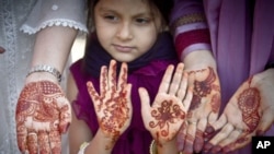 Muslim women a girl show their hands decorated with Henna, after Eid al-Fitr prayers in Bucharest, Romania, Tuesday, Aug 30, 2011.