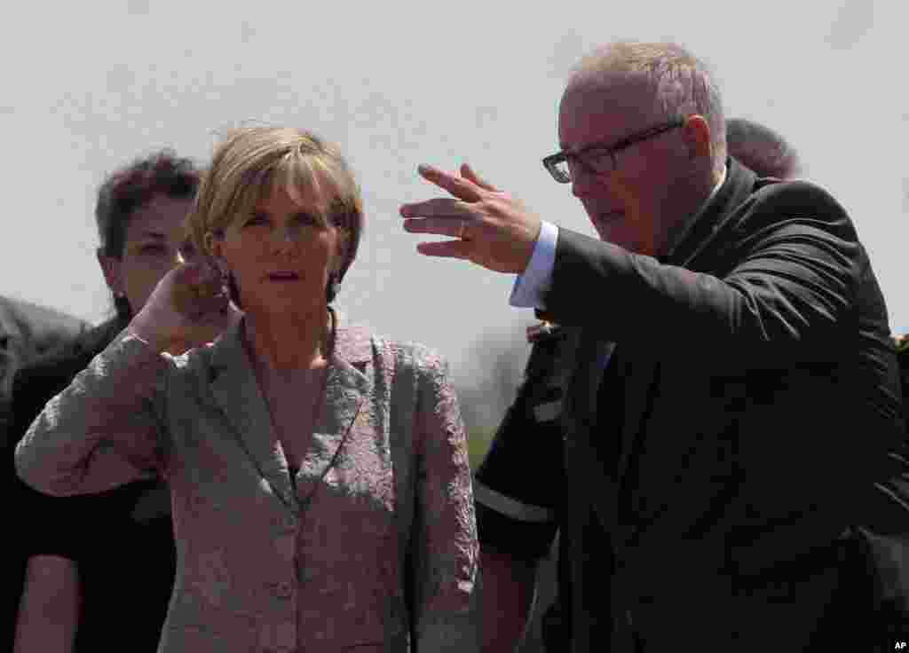 Netherlands Foreign Minister Frans Timmermans, right, and Australian Foreign Minister Julie Bishop speak to each other as a Dutch military cargo plane with bodies of some of the passengers of the downed Malaysia Airlines jetliner leaves Ukraine, July 25, 2014.