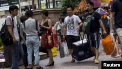 Chinese tourists carry shopping bags in Hong Kong's Causeway Bay shopping district, Sept. 21, 2015.