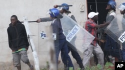 FILE: Armed Zimbabwean police clash with rioters in Harare, Monday, July 4, 2016. (AP Photo/Tsvangirayi Mukwazhi)