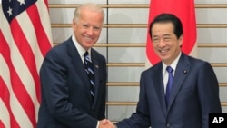 U.S. Vice President Joe Biden, left, is greeted by Japanese Prime Minister Naoto Kan prior to their meeting at Kan's official residence in Tokyo Tuesday, Aug. 23, 2011. (AP Photo/Itsuo Inouye)