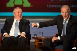 Vice President Joe Biden gestures toward former Vice President Walter Mondale as they participate in a forum honoring Mondale’s legacy, at George Washington University in Washington, Oct. 20, 2015.