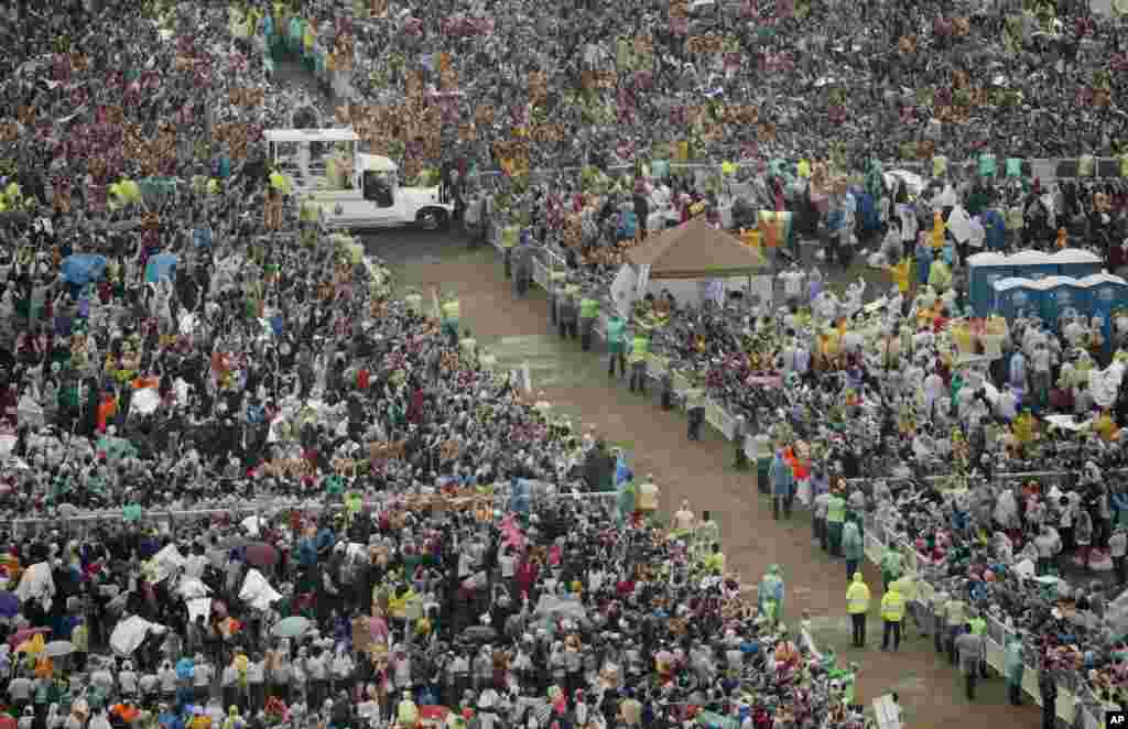 Pope Francis, in vehicle, waves to the faithful as he arrives at Rizal Park to celebrate his final Mass in Manila, Jan. 18, 2015.