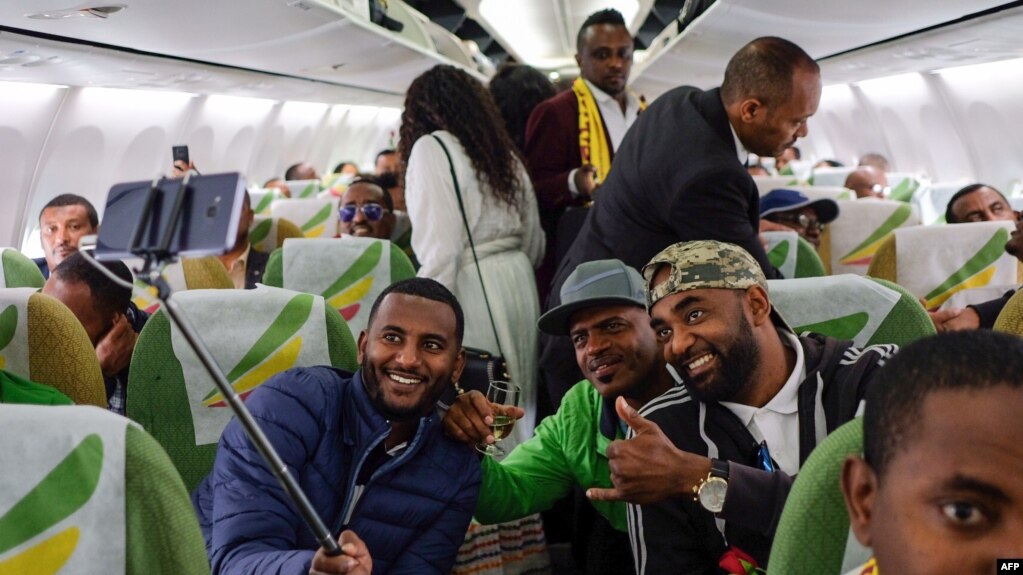 Passengers pose for a selfie picture inside an Ethiopian Airlines flight which departed from the Bole International Airport in Addis Ababa, Ethiopia, to Eritrea's capital Asmara on July 18, 2018. 