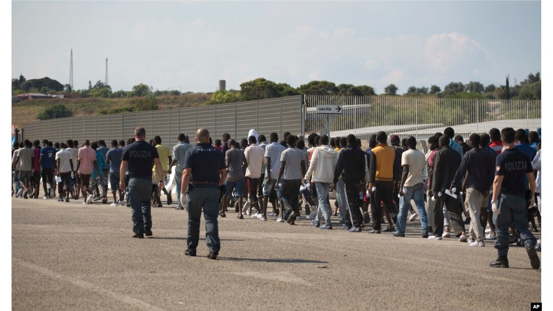 Arhiva - Italijanska granična policija sprovodi migrante iz podsaharskih zemalja u centar za relokaciju, nakon što su stigli spasilačkim brodom u Augustu, na Siciliji, Italija, 23. juna 2017.