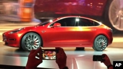 FILE - Tesla Motors unveils the new lower-priced Model 3 sedan at the Tesla Motors design studio in Hawthorne, California, March 31, 2016. 