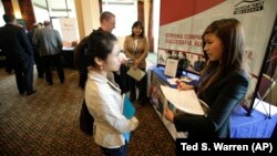 Eastern Washington University student Lihn Phung, talks to Lieu Vo, an agency sales manager assistant with American Family Insurance, about internship opportunities during a National Career Fairs job fair. 