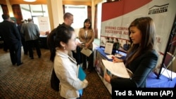 Eastern Washington University student Lihn Phung, talks to Lieu Vo, an agency sales manager assistant with American Family Insurance, about internship opportunities during a National Career Fairs job fair. 