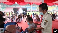 Seorang penyandang disabilitas menerima suntikan vaksin COVID-19 Sinovac saat vaksinasi massal di Stadion Patriot Candrabhaga, Bekasi, Senin, 14 Juni 2021. (AP Photo/Achmad Ibrahim)
