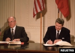 U.S. President Ronald Reagan (R) Soviet President Mikhail Gorbachev sign the Intermediate-range Nuclear Forces (INF) treaty in the White House in Washington December 8, 1987.
