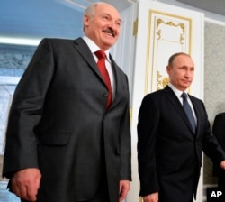FILE - Russian President Vladimir Putin and Belarusian President Alexander Lukashenko (l) meet in Minsk, Belarus, Feb. 25, 2016.