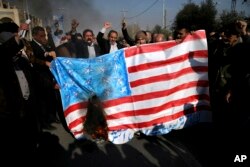 Iranian worshippers chant slogans while they burn a representation of U.S. flag during a rally against anti-government protesters after the Friday prayer ceremony in Tehran, Iran, Jan. 5, 2018.