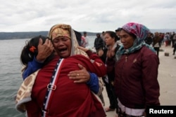 Para kerabat melepas tangis menunggu berita anggota keluarga mereka yang hilang dalam kapal feri KM Sinar Bangun yang tenggelam di Danau Toba, di Pelabuhan Tigaras, Simalungun, Sumatra Utara, 19 Juni 2018.