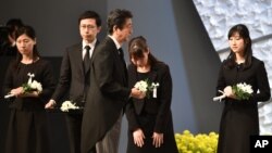 11일 도쿄에서 열린 동일본 대지진 참사 5주년 추모행사에서 아베 신조 일본 총리(가운데)가 희생자들에게 헌화할 꽃을 들고 걸어가고 있다.